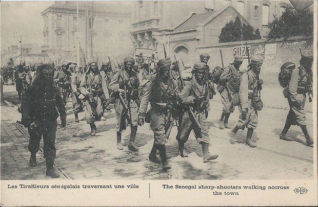 "Les Tirailleurs sénégalais traversant une ville" (Die "Senegalschützen" ziehen durch eine Stadt). Carte Postale, ungelaufen, ohne Datum. Sammlung Detlev Brum.