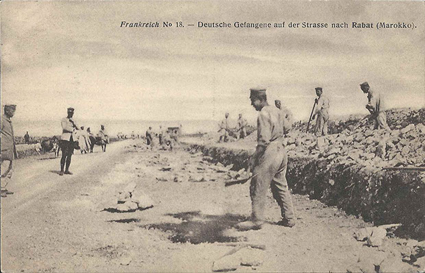 "Deutsche Gefangene auf der Strasse nach Rabat (Marokko)". Postkartenserie des "Comité International de la Croix-Rouge, Genéve", Kriegsgefangenenlager, Frankreich, Nr. 18. Ansichtskarte, ungelaufen. Sammlung Detlev Brum. Die Motive der Ansichtskarten sind mit einiger Wahrscheinlichkeit 1915 auch in Dortmund bei einem Bericht des Roten Kreuzes gezeigt worden. Die sozialdemokratische Arbeiter-Zeitung kommentierte: "Malerische Bilder zogen vorüber und mancher geriet wohl in recht eigene Stimmung, als er die deutschen Gefangenen in der Wüste Sahara und in anderen Gegenden Afrikas Steine klopfen oder karren sah."