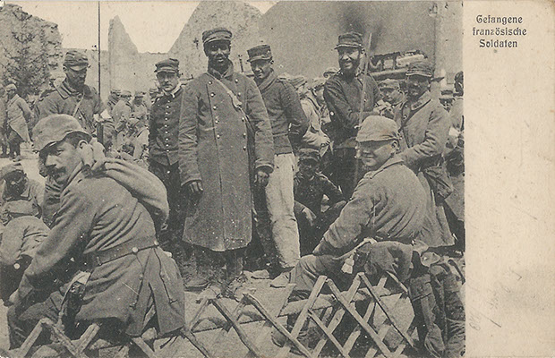 "Gefangene französische Soldaten". Ansichtskarte, gelaufen als Feldpost im September 1915. Sammlung Detlev Brum. In deutschen Ansichtskarten mit Motiven aus improvisierten Gefangenenlagern werden häufig afrikanische Soldaten in den Bildmittelpunkt gerückt.
