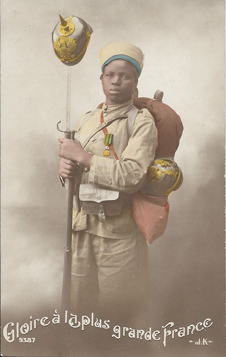 "Gloire à la plus grande France". Französische Ansichtskarte, gelaufen innerhalb Frankreichs im Mai 1915. Sammlung Detlev Brum. Ordensgeschmückt und mit einer mit dem Bajonett aufgespiesten deutschen Pickelhaube. Zu den in Frankreich beliebten Motiven im Ersten Weltkrieg zählten Aufnahmen von afrikanischen Kindersoldaten bzw. Kindern in Uniform "aus dem größeren Frankreich".