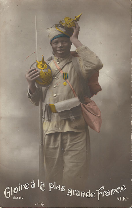 "Gloire à la plus grande France". Französische Ansichtskarte, beschriftet im April 1917. Sammlung Detlev Brum. "Ehre sei dem größeren Frankreich": Zu den in Frankreich beliebten Motiven im Ersten Weltkrieg zählten Aufnahmen von afrikanischen KIndersoldaten bzw. Kindern in Uniform, hier mit erbeuteter deutscher Pickelhaube.