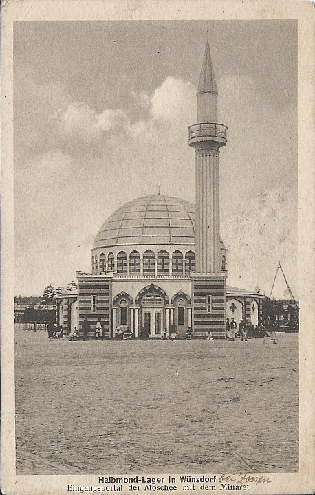 "Halbmond-Lager in Wünsdorf. Eingangsportal der Moschee mit dem Minaret". Ansichtskarte, s/w, gelaufen im September 1915 von Zossen nach München. Sammlung Detlev Brum. Vermutlich ist die Moschee im Kriegsgefangenenlager Wünsdorf-Zossen eines der am häufigsten genutzten Motive deutscher Ansichtskarten. Es existieren zahlreiche Varianten und Nachdrucke, die sowohl als Feldpost als auch im privaten Briefverkehr in Umlauf gebracht wurden.