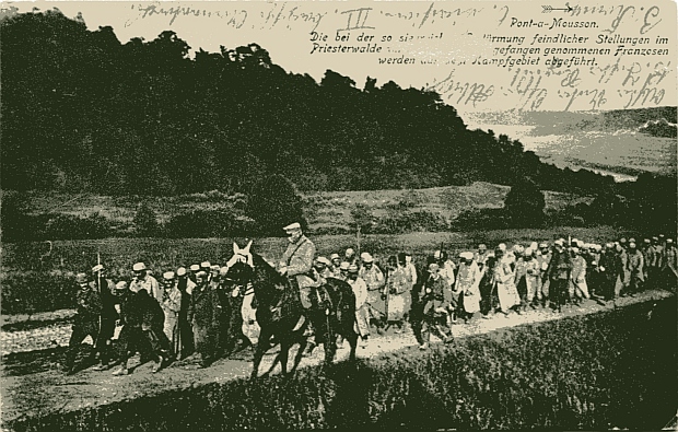 "Pont-a-Mousson. Die bei der so siegreichen Erstürmung feindlicher Stellungen im Priesterwalde am 4. Juli 1915 gefangen genommenen Franzosen werden aus dem Kampfgebiet abgeführt". Ansichtskarte ("genehmigte Originalaufnahme"), gelaufen im September 1915 als Feldpost. Sammlung Markus Kreis. Bei näherer Betrachtung ist zu erkennen, das v.a. Soldaten aus den Kolonien in die Gefangenschaft eskortiert werden.