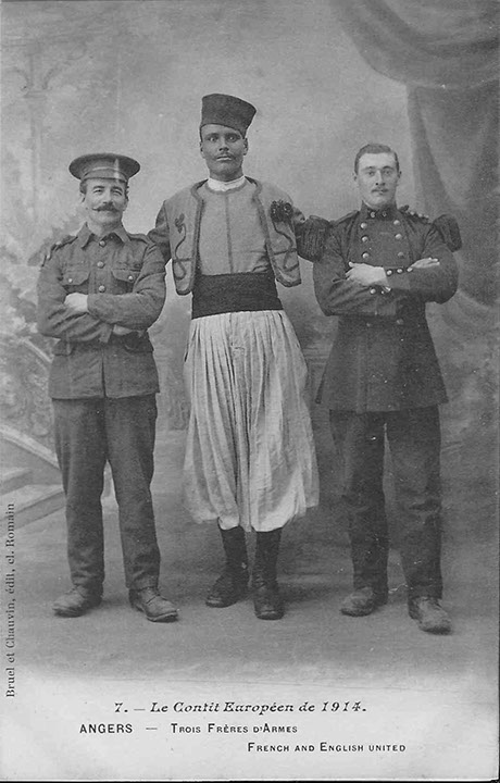 "Le Conflit Européen de 1914. Angers - Trois Fréres d‘armes" (Drei Waffenbrüder). Carte Postale, ungelaufen. Sammlung Detlev Brum. Drei Waffenbrüder oder "French and English United"? Ist der afrikanische "Waffenbruder" als Franzose "integriert"? Auf französischen wie deutschen Ansichtskarten zum Ersten Weltkrieg werden gerne hünenhafte Afrikaner in Szene gesetzt, bei den einen als Ausdruck der hinzugewonnenen Stärke, bei den anderen als Ausdruck der drohenden Gefahr. Das Motiv der Ansichtskarte bricht scheinbar traditionelle koloniale Sehgewohnheiten, weil der Afrikaner kumpelhaft oder gar beschützend seine Hände auf die Schultern der beiden Waffenbrüder legt. Das Grinsen der beiden Waffenbrüder deutet die Wiederherstellung der kolonialen Ordnung an: Alles nicht so ernst gemeint, oder?